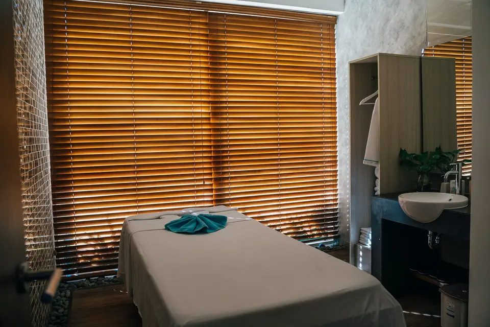 Ruang perawatan dengan tempat tidur dan tirai kayu